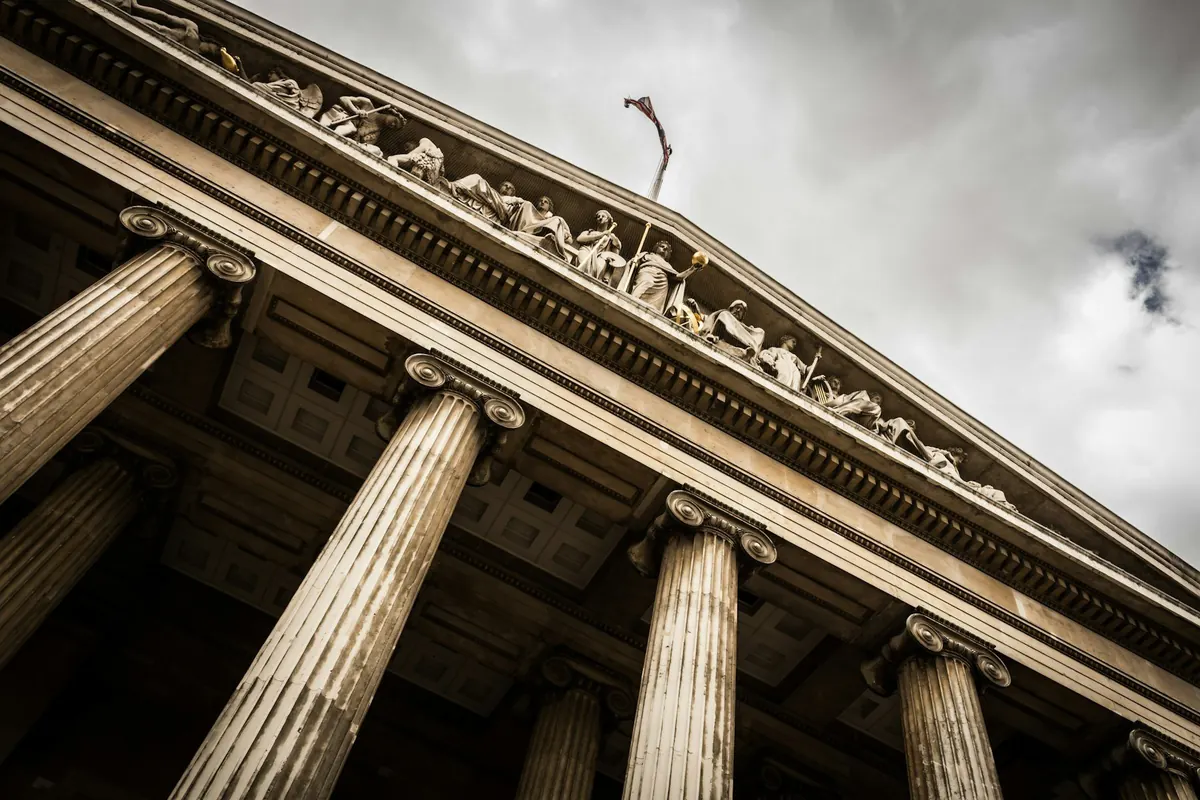 The columns of a classical courthouse seen from below — criminal defence in Trinidad and Tobago