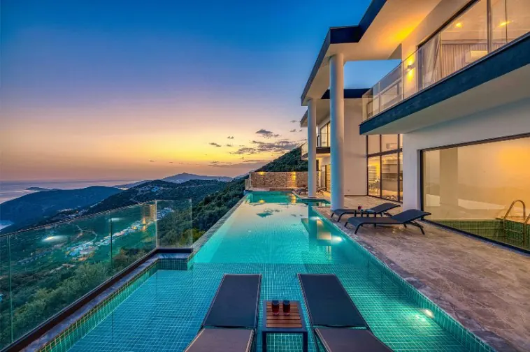 A hillside house and pool at sunset — property, building and conveyancing