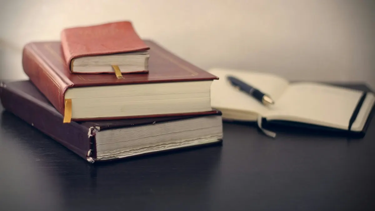 The file Leather-bound books and a pen on a desk