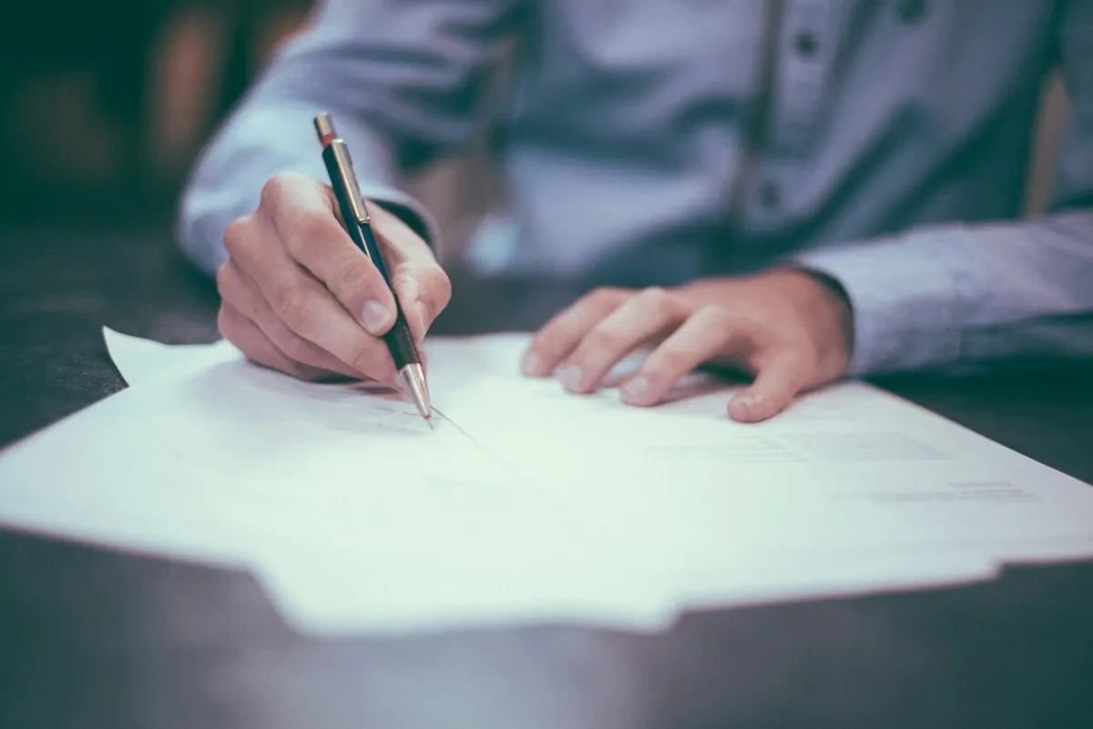 A hand setting out a matter on paper — making an enquiry