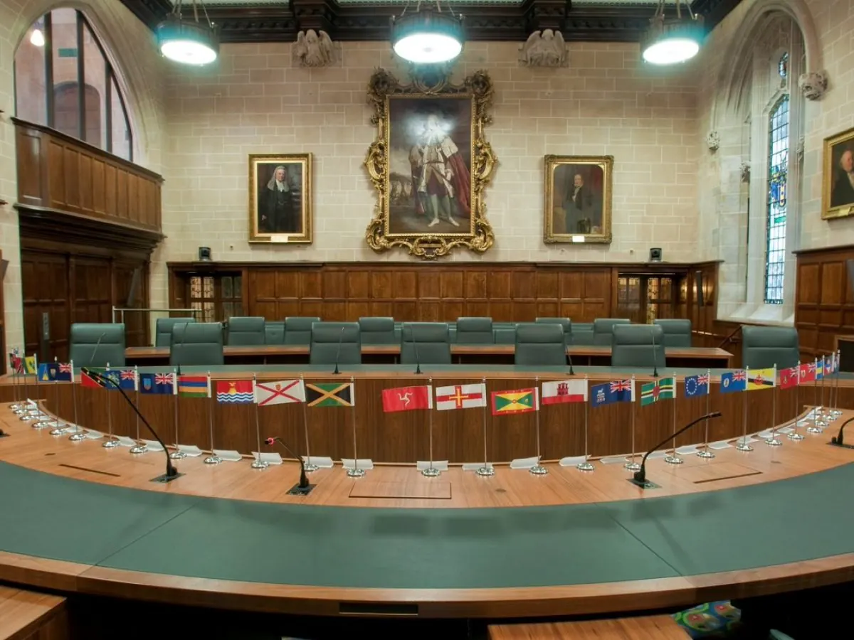 The Judicial Committee of the Privy Council, the final court of appeal for Trinidad and Tobago: a curved bench, Commonwealth flags along it, portraits above